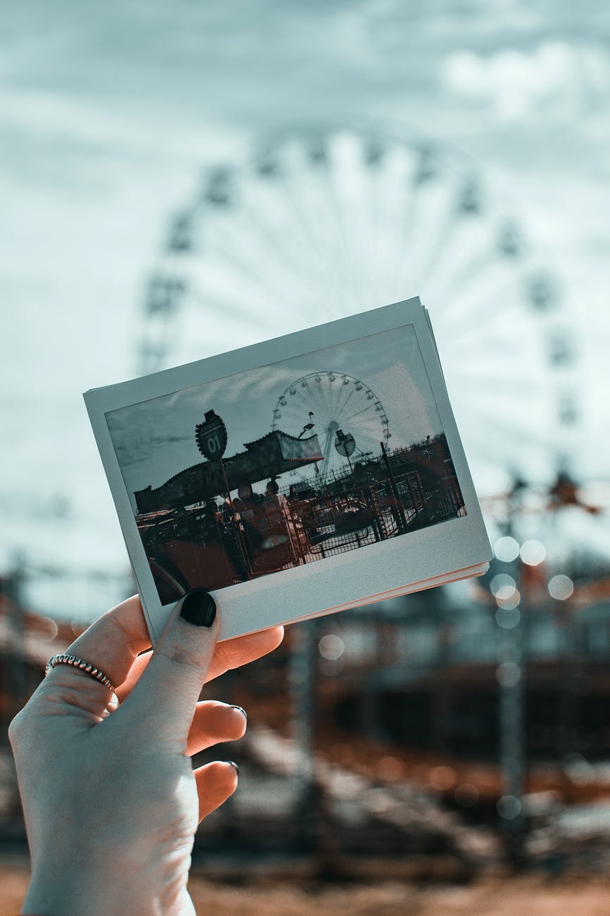 person holding photo of amusement park